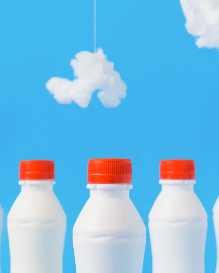 Milkbottles in bottom of image, clouds made of cotton suspended with string